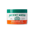 AC01_main "A container of "Ancient Mayan Indian Healing Clay." The container is predominantly green and white with orange accents. The lid is green and features the brand name "KISS" in red letters. Below the brand name, there is a circular emblem with a 