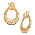 JE530_main "A pair of gold-toned hoop earrings with a unique, ribbed design. Each earring has a rounded, oval shape with a textured surface that resembles a series of connected segments or ridges. The top part of the earrings is slightly wider and feature