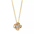 JN017_main "A beautiful gold necklace with a delicate chain. The pendant is designed in an intricate knot shape, adorned with sparkling clear stones that enhance its elegance. At the center of the pendant, there is a prominent round gemstone that catches 