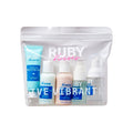 RHSTK01_main "A skincare travel set from the brand "Ruby Kisses." The set is packaged in a clear plastic bag with a resealable zipper. The bag contains several small bottles and tubes of skincare products, including a hydrating moisturizer, a cleanser, and other skincare items. The packaging is predominantly white and light blue, with the brand name "Ruby Kisses" prominently displayed in white and pink text on the front of the bag."