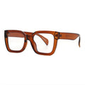 SUN27V5_main "A pair of oversized, square-shaped glasses with a bold, amber-colored frame. The lenses are clear, and the design has a modern, stylish aesthetic. The arms of the glasses are slightly tapered, adding to their contemporary look. Overall, the 
